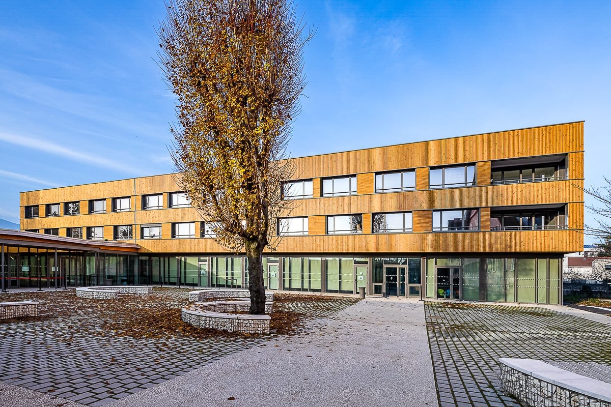 Photographie d'architecture de la cour et façade en bois de l'internat