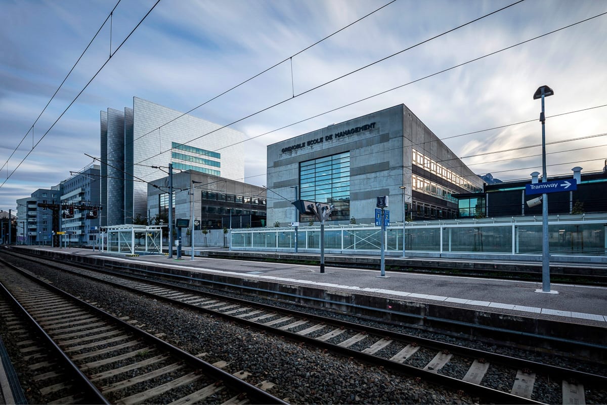 Photographie d'architecture en début de soirée, de la voie ferrée devant les bâtiments de l'école