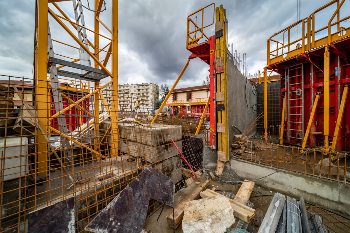 Capharnaüm de chantier avec une grue, des murs et des éléments de coffrage