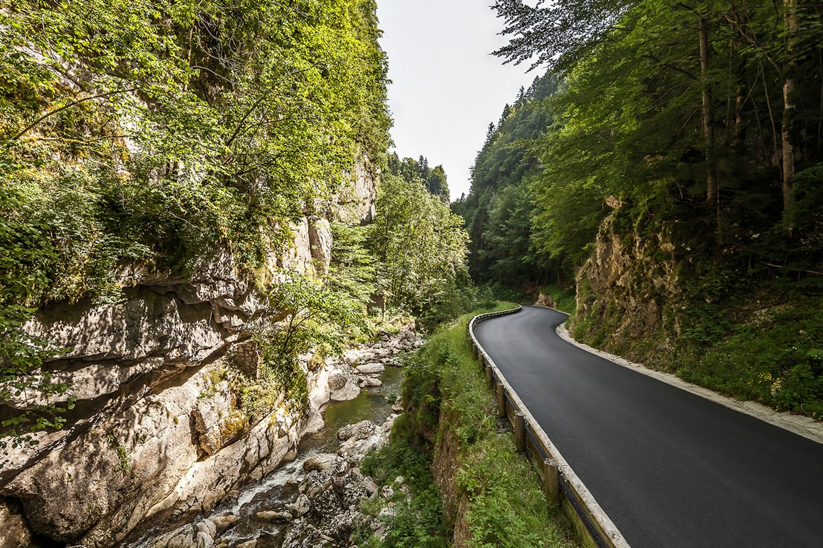 Vue globale d'une route neuve et d'un torrent au départ d'une gorge montagneuse